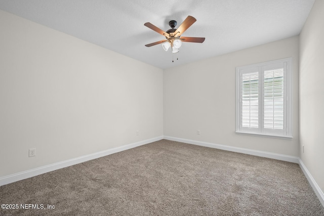 empty room with baseboards, a ceiling fan, and carpet