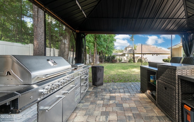 view of patio / terrace with a fenced backyard, grilling area, and exterior kitchen