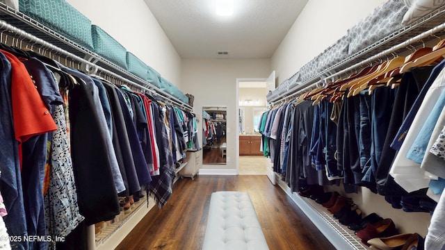 walk in closet with wood finished floors
