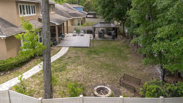 view of yard with a gazebo, a wooden deck, a fenced backyard, and an outdoor living space with a fire pit