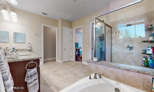bathroom featuring tile patterned flooring, vanity, baseboards, a tub with jets, and visible vents