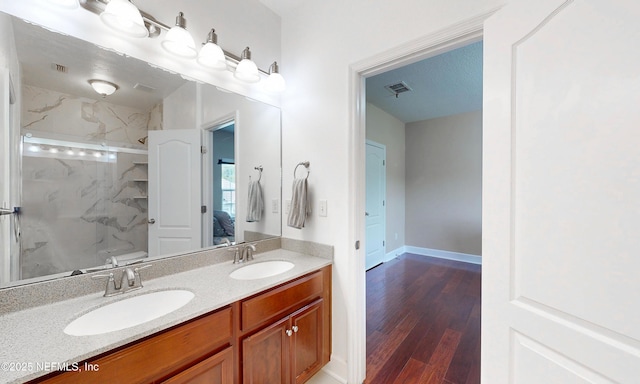 ensuite bathroom with a sink, a marble finish shower, ensuite bath, and visible vents
