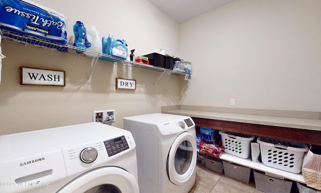 clothes washing area with washer and dryer, light tile patterned flooring, and laundry area