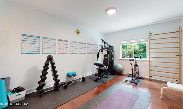 exercise area with baseboards and wood finished floors