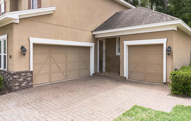 garage with decorative driveway
