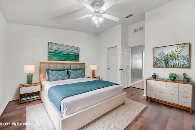 bedroom with baseboards, visible vents, and wood finished floors