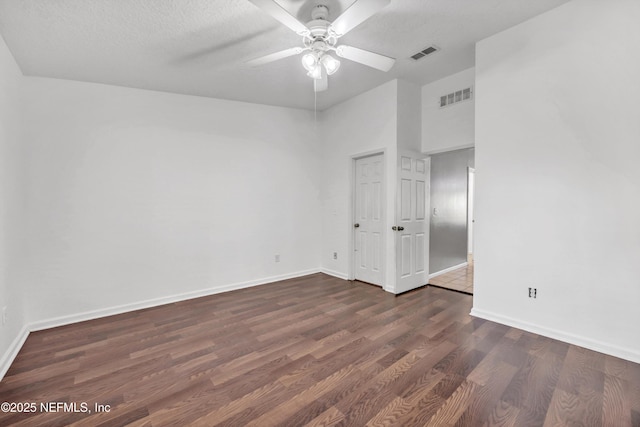 unfurnished room featuring baseboards, ceiling fan, dark wood-style floors, and visible vents