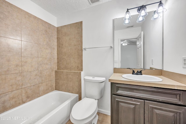 bathroom with visible vents, vanity, toilet, ceiling fan, and a textured ceiling