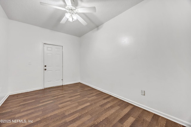 unfurnished room featuring a ceiling fan, baseboards, a textured ceiling, and dark wood-type flooring