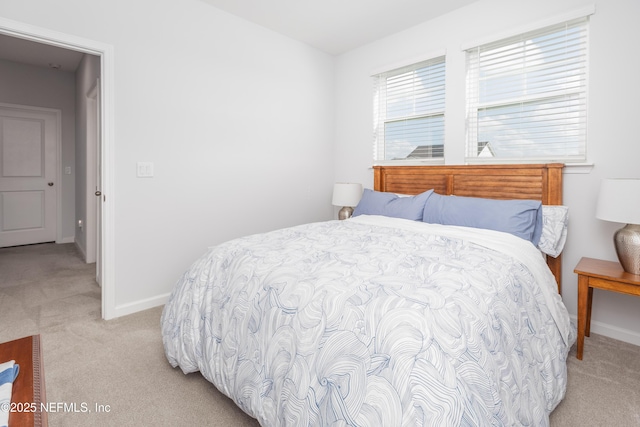 bedroom featuring baseboards and light colored carpet