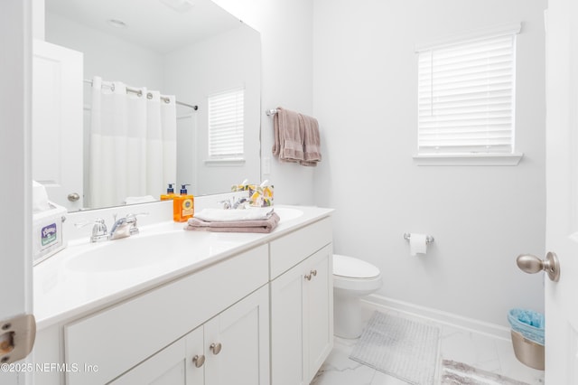 bathroom with double vanity, toilet, a sink, and marble finish floor