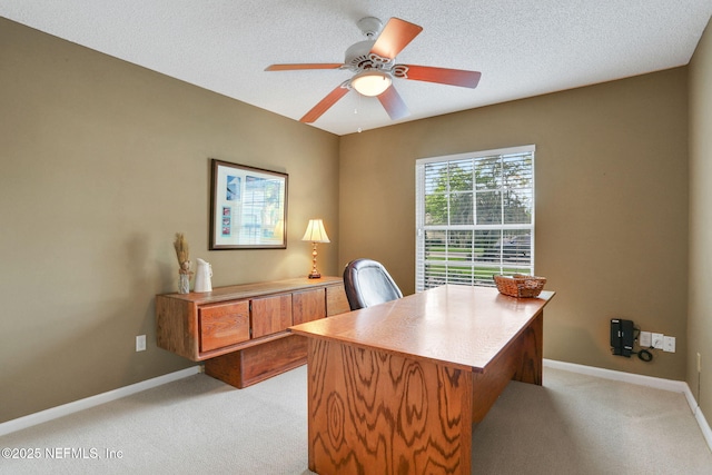 office with a ceiling fan, baseboards, and light colored carpet