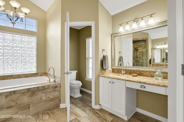 bathroom with vanity, toilet, a bath, a chandelier, and a stall shower