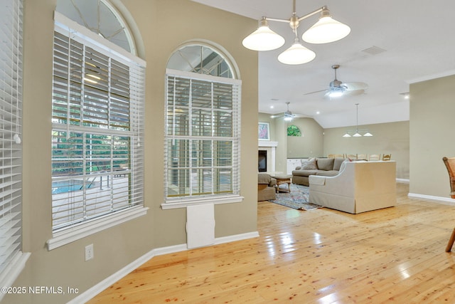 living room with a ceiling fan, baseboards, and wood finished floors