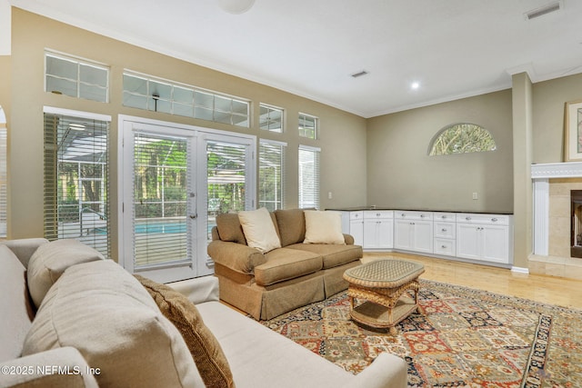 living room with visible vents, ornamental molding, light wood-style floors, recessed lighting, and french doors