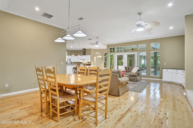 dining area featuring arched walkways, ceiling fan, light wood-type flooring, and visible vents