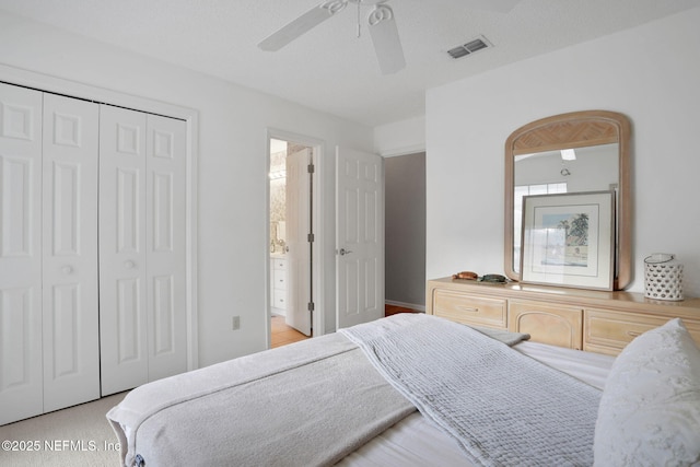 bedroom featuring ceiling fan, visible vents, a closet, light wood finished floors, and connected bathroom