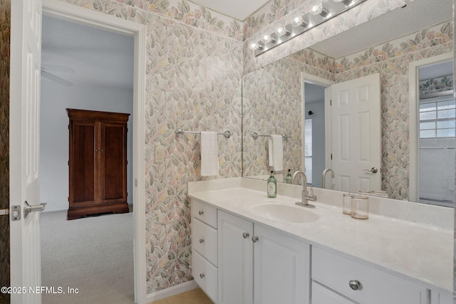 bathroom featuring vanity and wallpapered walls