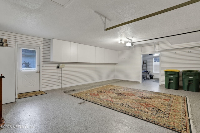garage with a garage door opener and white fridge