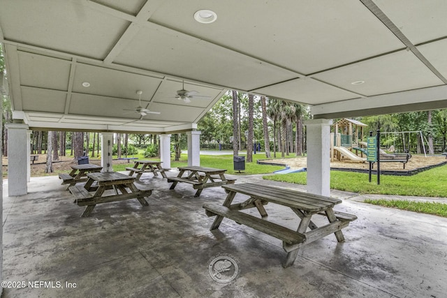 view of home's community featuring a lawn, a patio area, and playground community