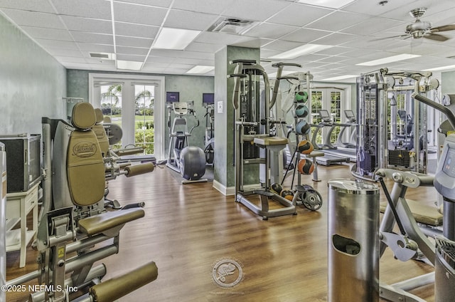 exercise room with visible vents, a paneled ceiling, ceiling fan, and wood finished floors