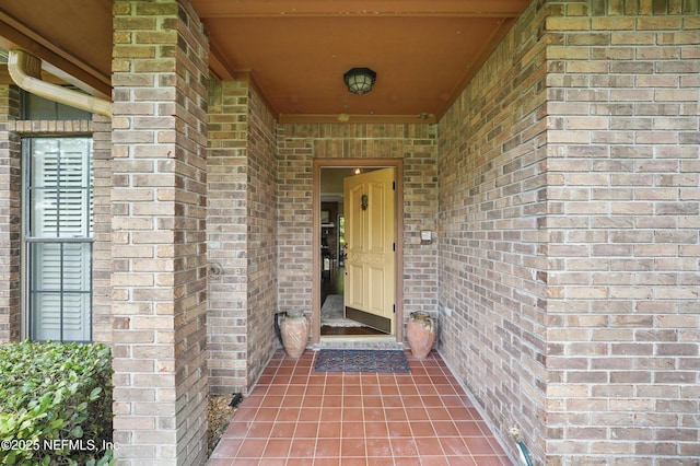 view of exterior entry with brick siding