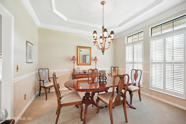 dining space featuring crown molding, a raised ceiling, baseboards, light carpet, and a notable chandelier
