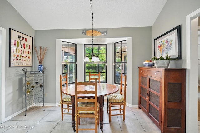 dining room featuring light tile patterned floors, a textured ceiling, lofted ceiling, and baseboards