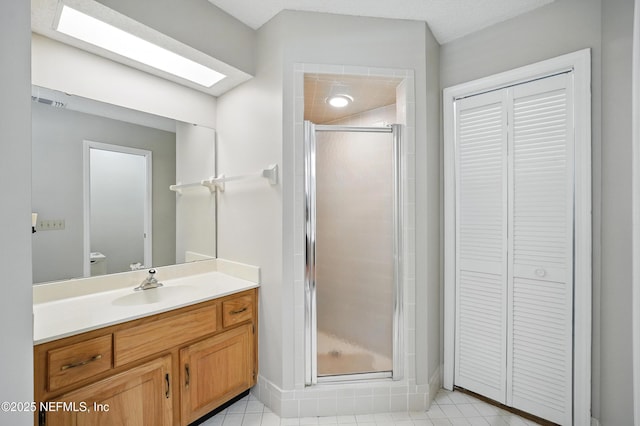 bathroom featuring a shower stall, baseboards, a closet, toilet, and vanity