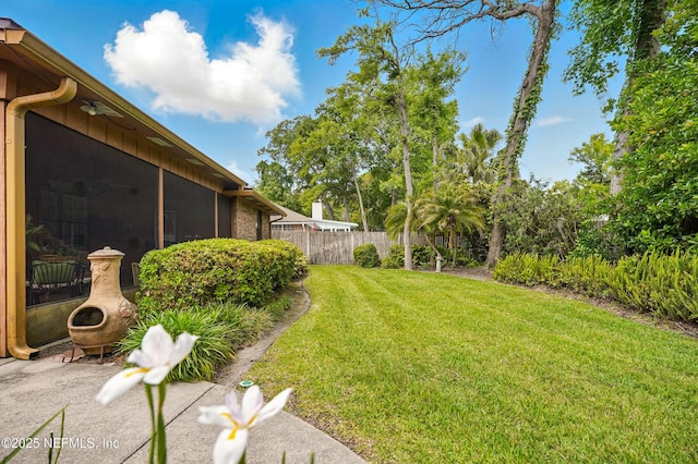 view of yard featuring fence and a sunroom