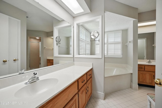 bathroom featuring a bath, tile patterned flooring, a sink, and a stall shower