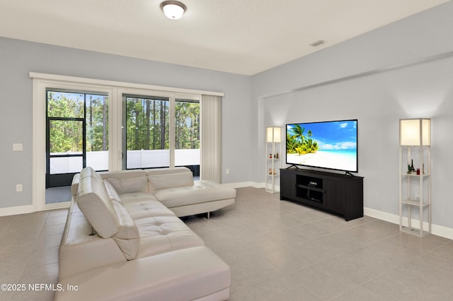 living room with light tile patterned floors, baseboards, and visible vents