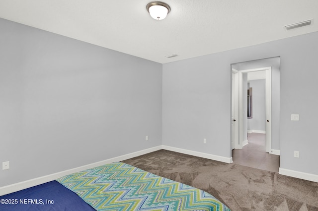 unfurnished room with baseboards, carpet, and visible vents
