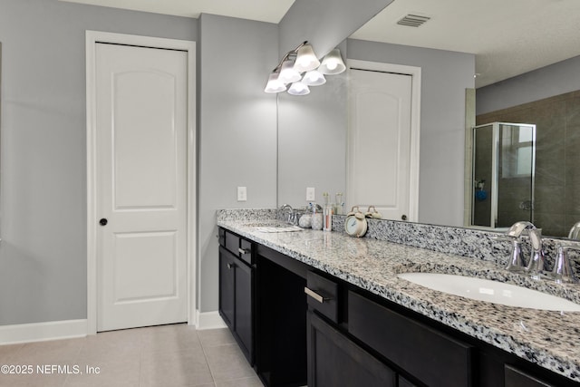 full bathroom featuring double vanity, a sink, tile patterned floors, and a shower stall