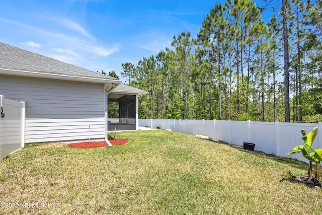 view of yard featuring a fenced backyard and a sunroom