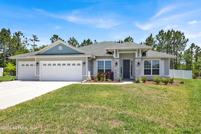 view of front of home featuring a front lawn, fence, stone siding, concrete driveway, and an attached garage