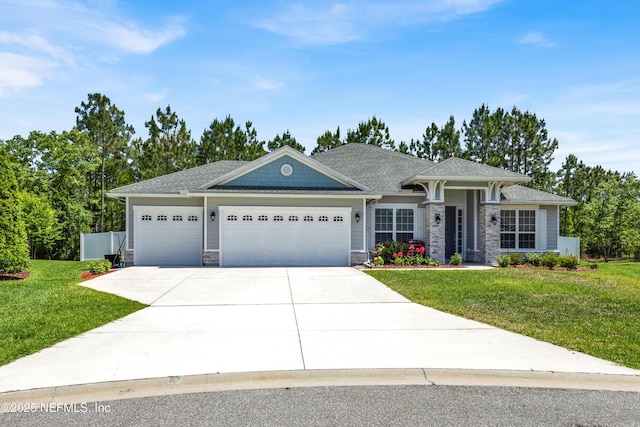 view of front of property with a garage, stone siding, driveway, and a front yard