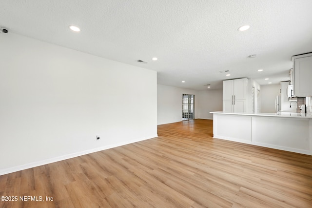 unfurnished living room featuring visible vents, recessed lighting, and light wood finished floors
