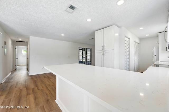 kitchen with light countertops, recessed lighting, wood finished floors, and white cabinetry