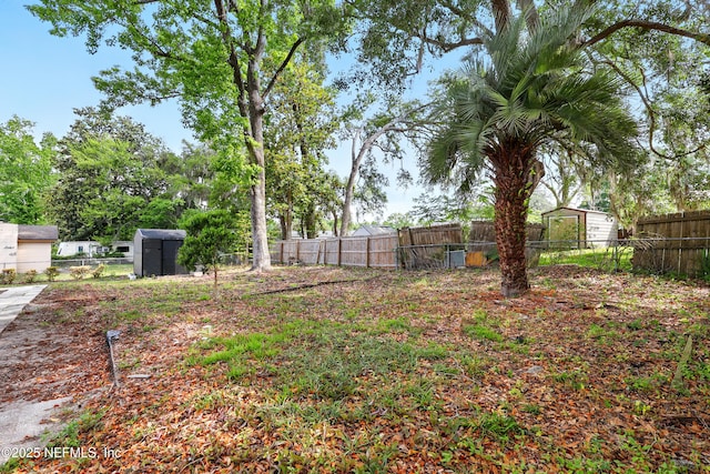 view of yard with an outdoor structure, a fenced backyard, and a storage shed