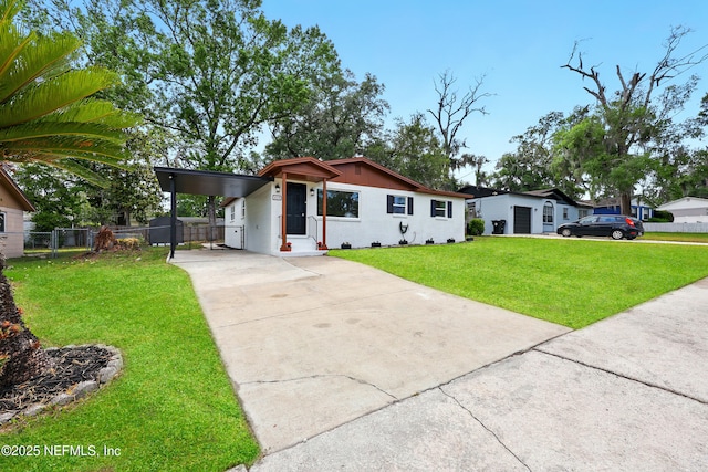 view of front facade featuring a front lawn, fence, an attached carport, and concrete driveway