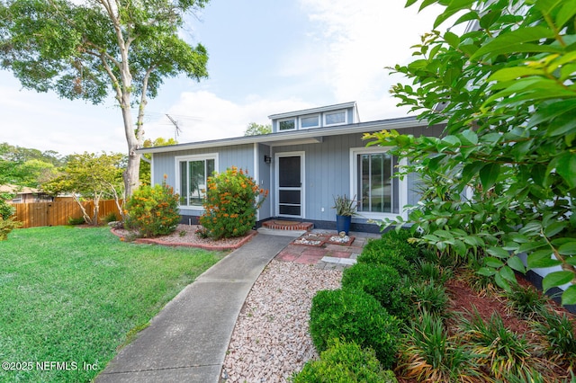 bungalow featuring fence and a front yard