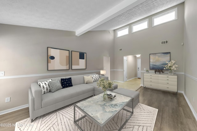 living area featuring visible vents, baseboards, wood finished floors, and beam ceiling
