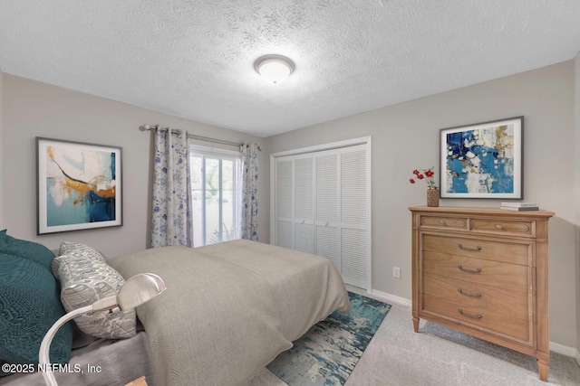 bedroom featuring a textured ceiling, baseboards, light carpet, and a closet