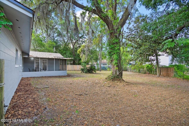 view of yard with a fenced backyard and a sunroom