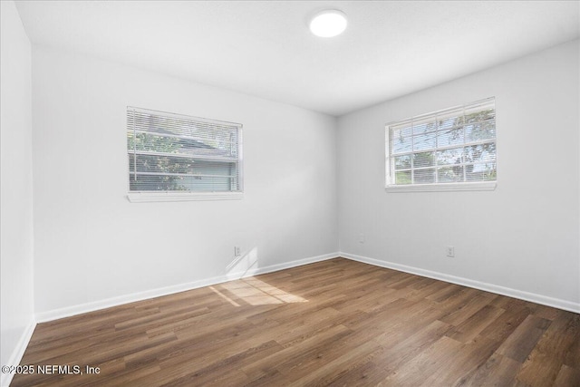 empty room with wood finished floors and baseboards