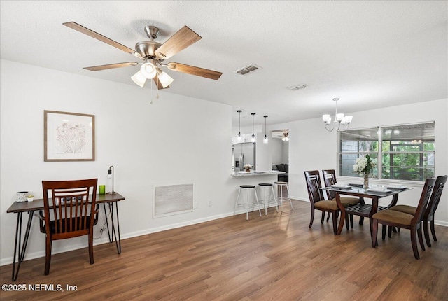 dining room with baseboards, visible vents, and wood finished floors