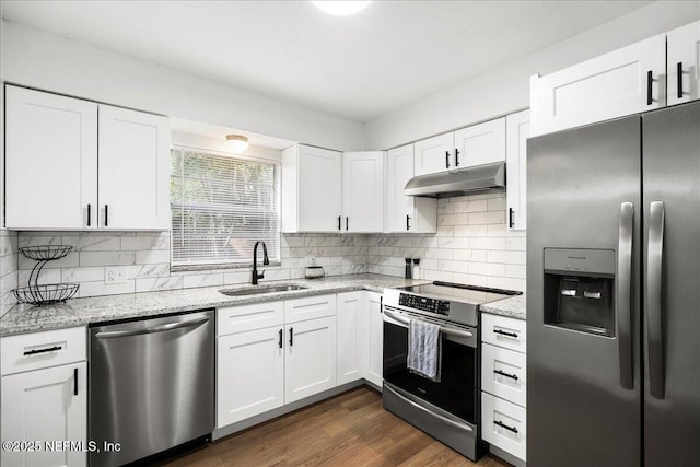 kitchen featuring light stone countertops, stainless steel appliances, under cabinet range hood, white cabinets, and a sink