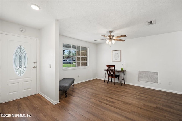 foyer entrance with a ceiling fan, visible vents, wood finished floors, and baseboards