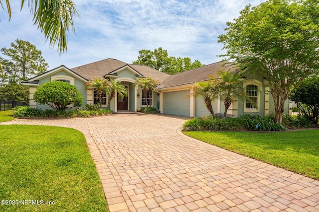 3771 Saltmeadow Ct S, Jacksonville, FL 32224 - mediterranean / spanish house featuring stucco siding, decorative driveway, an attached garage, and a front yard